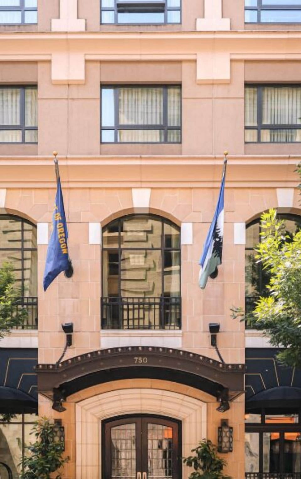 The charming facade of Hotel Dossier, accented with flags, welcomes guests with a promise of exceptional service and a memorable visit.