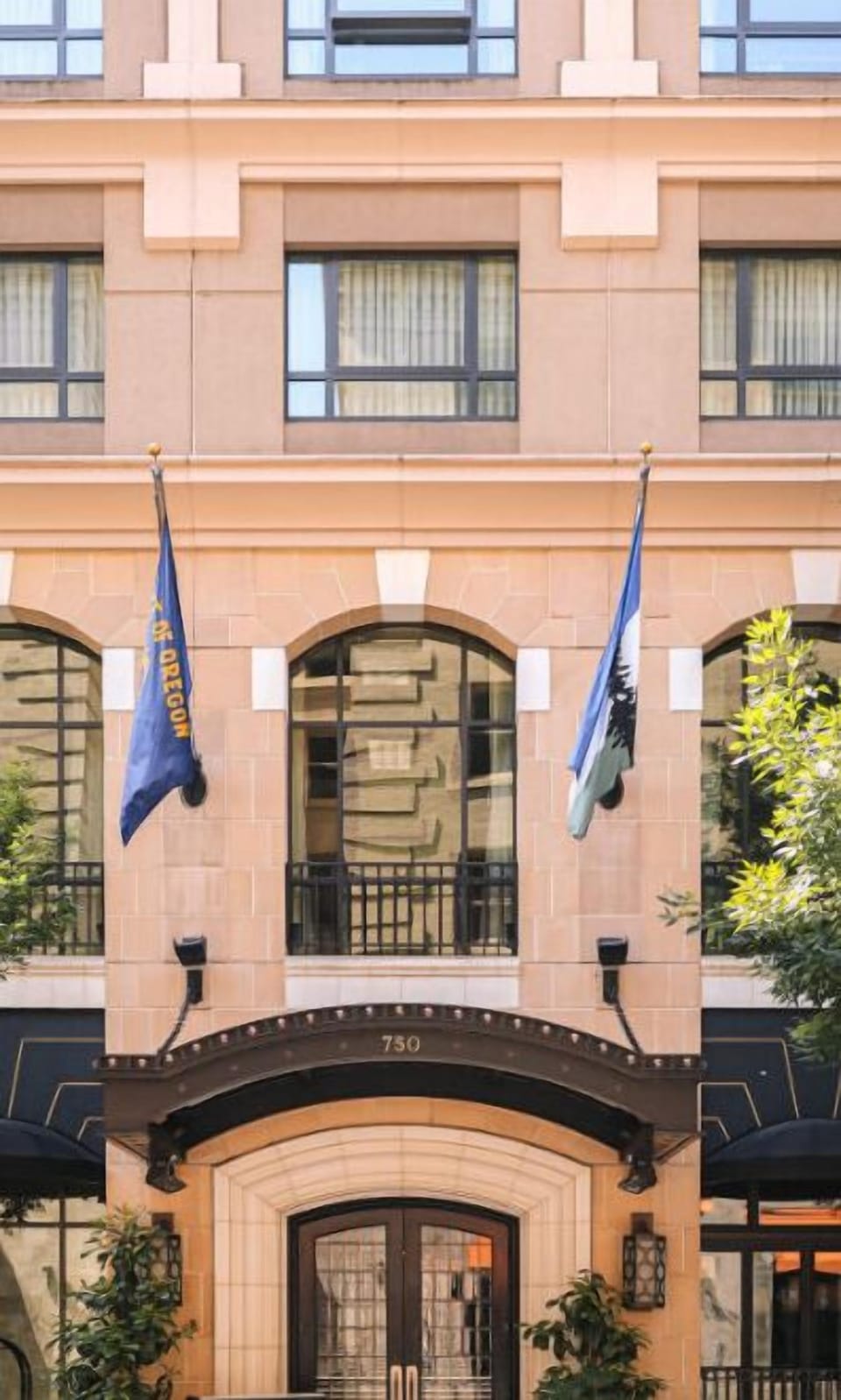 The charming facade of Hotel Dossier, accented with flags, welcomes guests with a promise of exceptional service and a memorable visit.