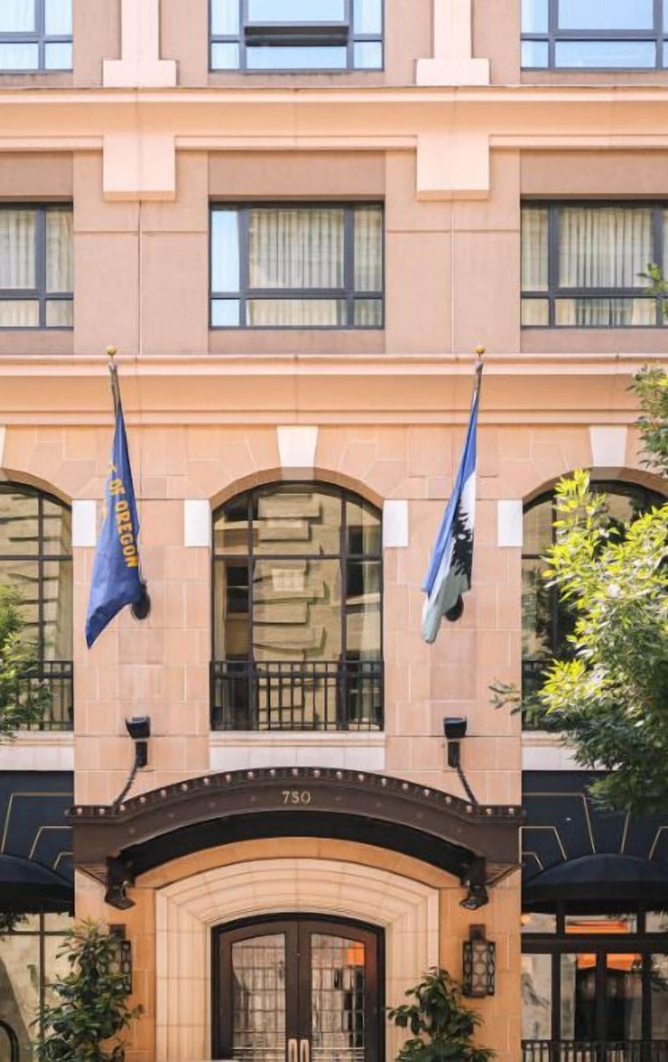 The charming facade of Hotel Dossier, accented with flags, welcomes guests with a promise of exceptional service and a memorable visit.