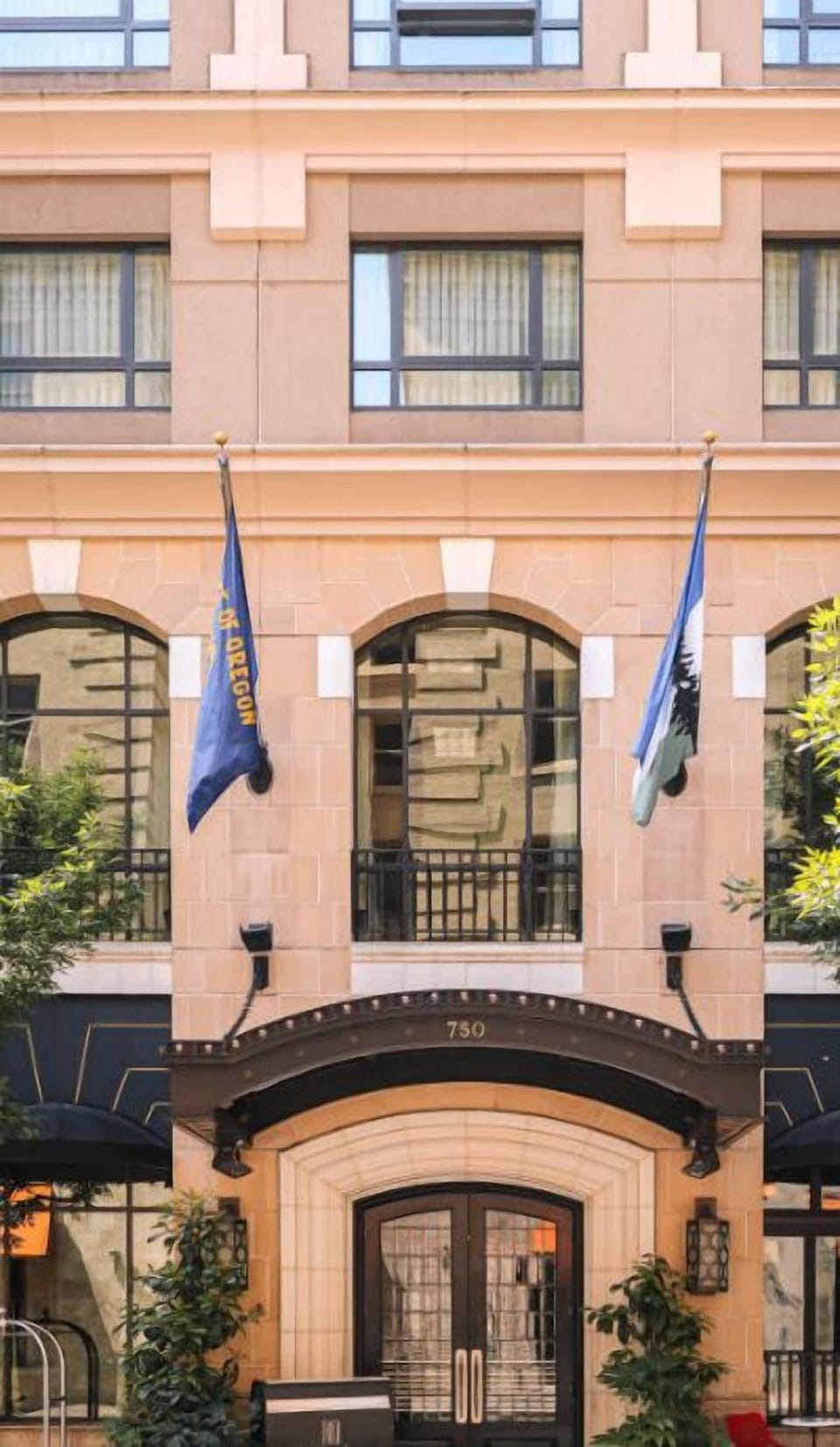 The charming facade of Hotel Dossier, accented with flags, welcomes guests with a promise of exceptional service and a memorable visit.