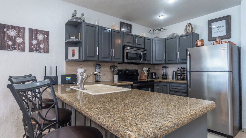 The complete kitchen is well laid out, with full appliances and cookware.