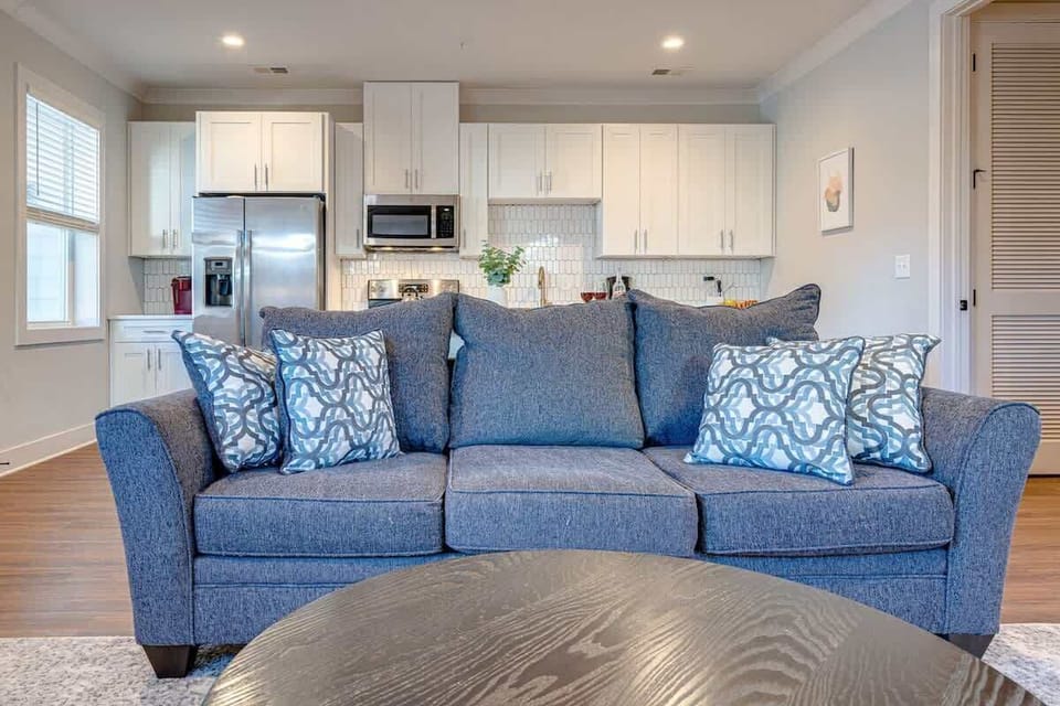 1st Unit: Open-floor plan featuring the cozy living room furnishings with a Smart TV seamlessly connecting to the fully equipped kitchen.