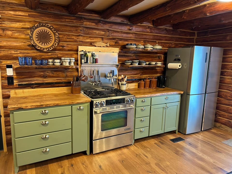 Kitchen with dual-fuel range, full-size fridge, and custom made cabinetry. 