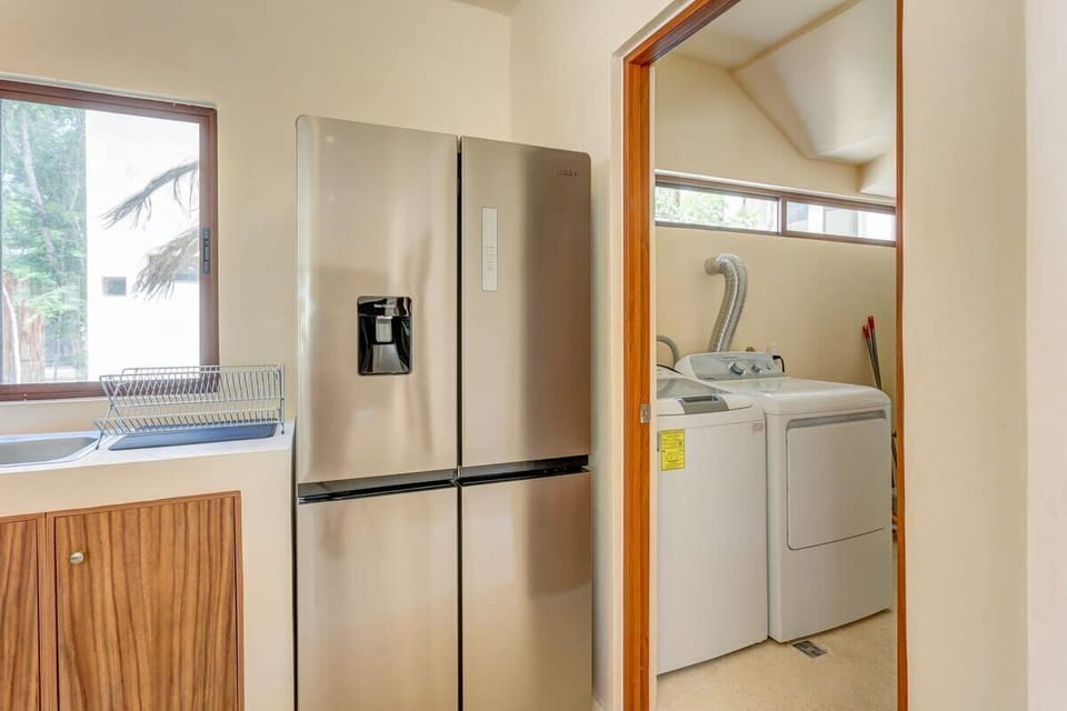 The laundry room with a washer and dryer is right next to the kitchen