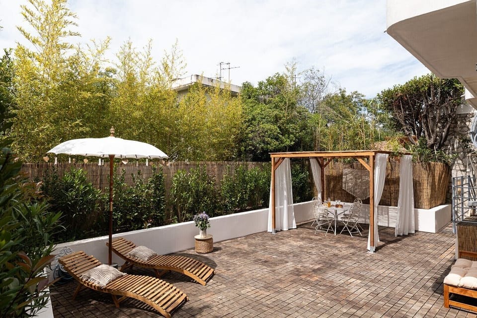Relaxation area of your accommodation with outdoor dining area and sunbeds, perfect for unwinding at Mandara Beach.