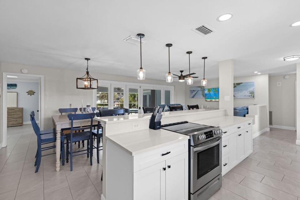Fully equipped kitchen with breakfast bar and dinning table looking out towards the pool..