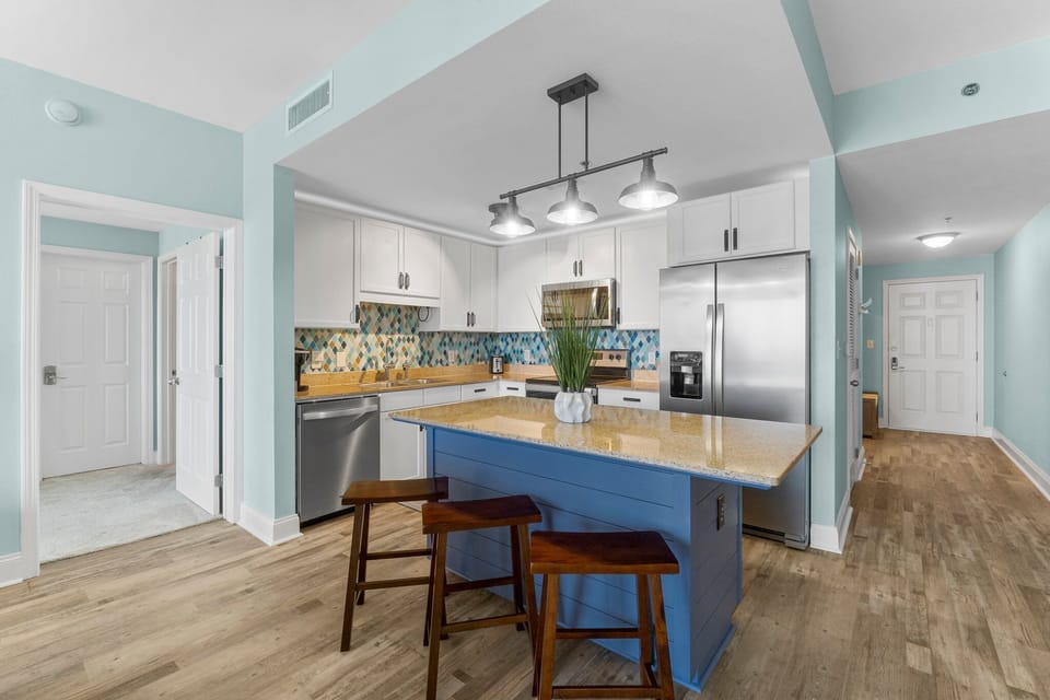Modern kitchen with a blue island and stainless steel appliances