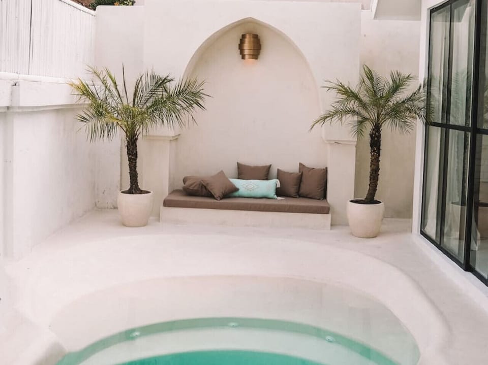 Cozy outdoor lounge with soft seating and tropical palm accents