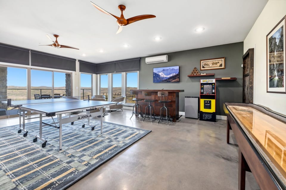Game room featuring a ping pong table, a shuffleboard table, and arcade games!