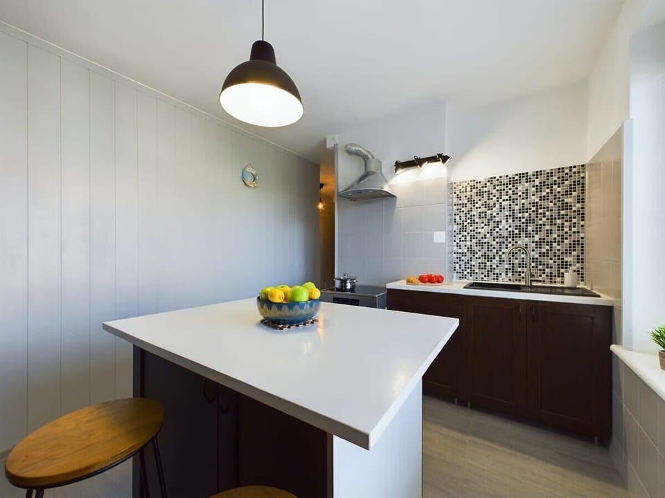 Functional kitchen with a modern breakfast bar and sleek stools.

