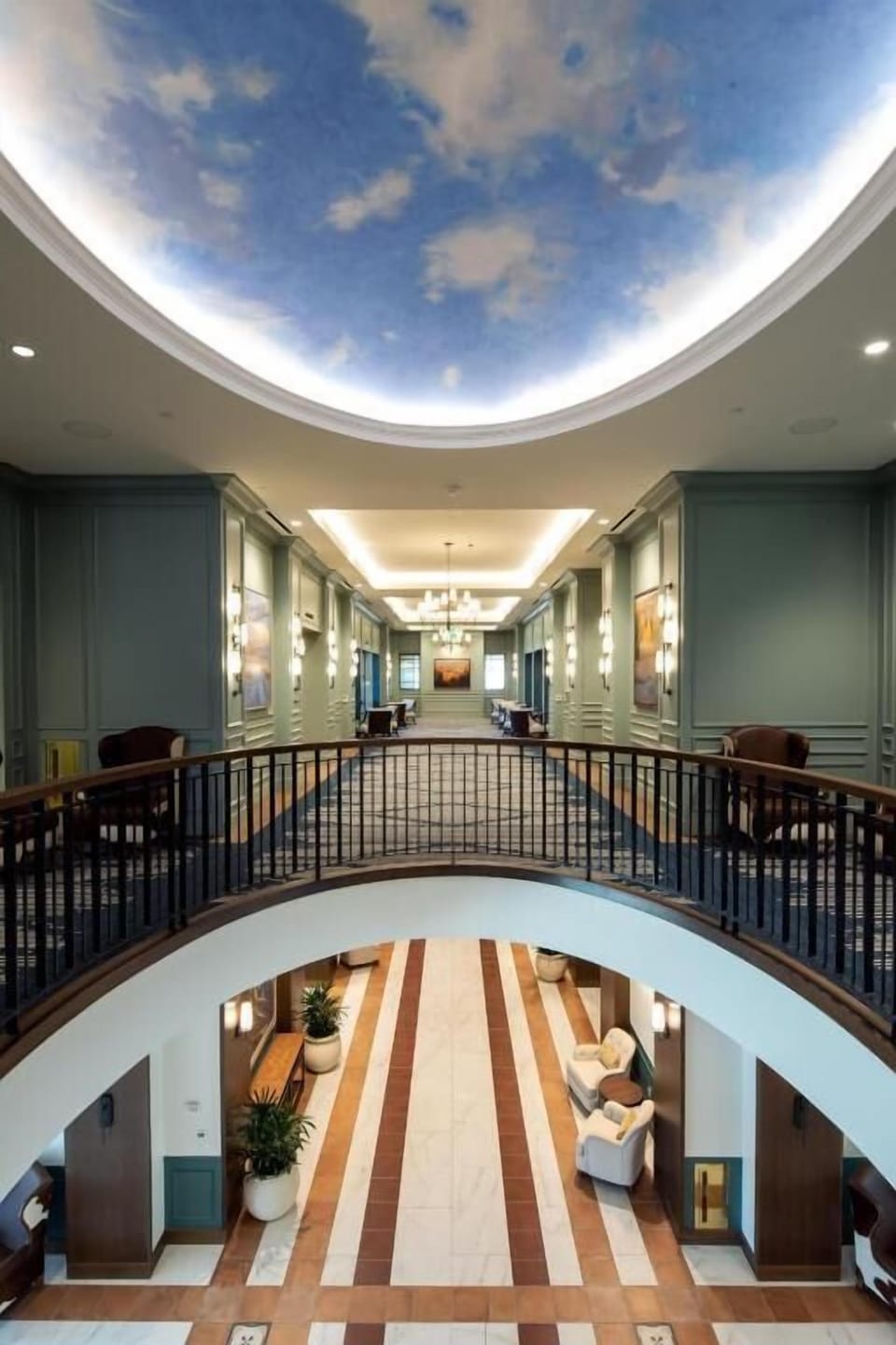 Step into a grand atrium beneath a painted sky ceiling.