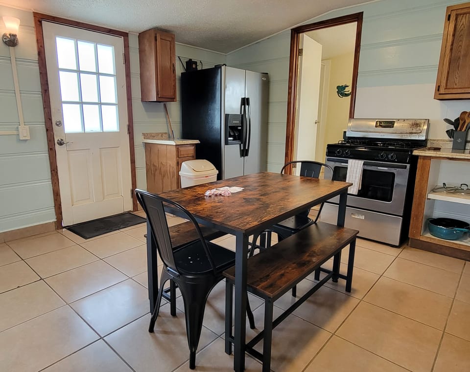The kitchen has a refrigerator, gas range, microwave, and coffee maker