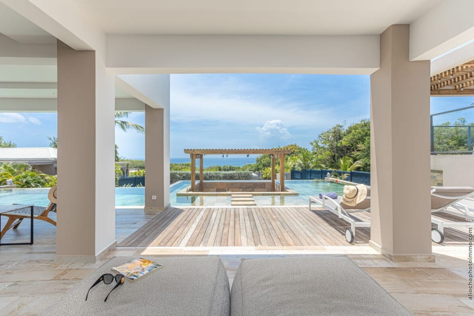 Unobstructed view from the covered terrace towards the infinity pool and the horizon.