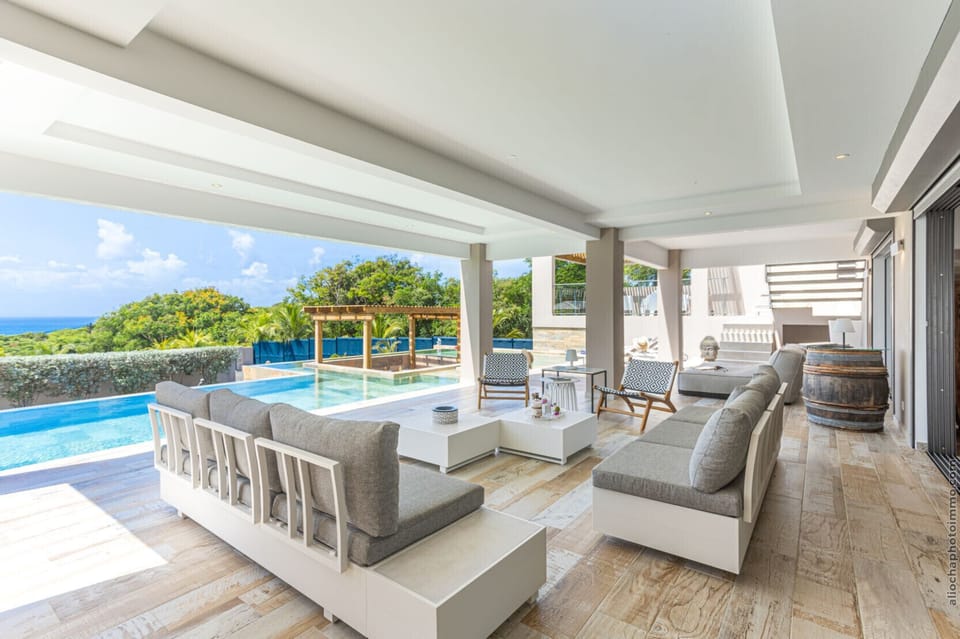 Spacious garden lounge and infinity pool with views of the Caribbean horizon.