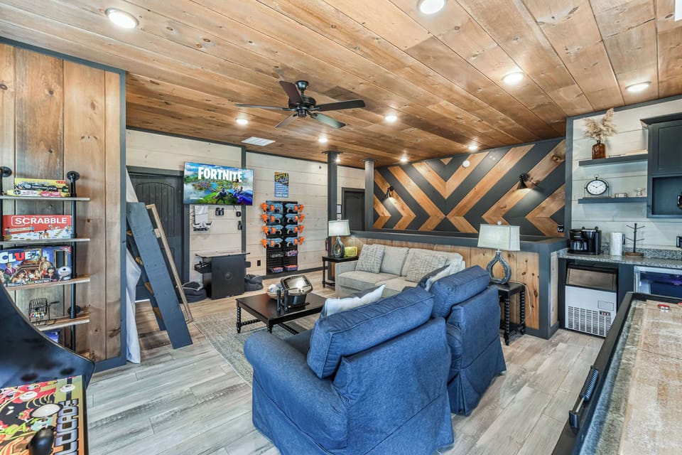 Rustic game room featuring a large tv, board games, and comfortable seating for family fun.