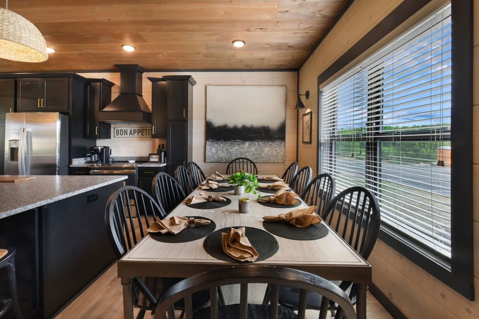 Modern dining area with seating for eight and a view of the kitchen.