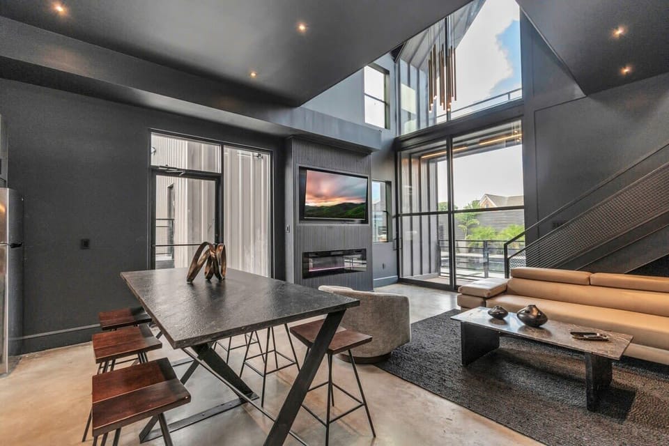 Enjoy meals al fresco with a modern dining setup, complemented by floor-to-ceiling windows that invite natural sunlight indoors.