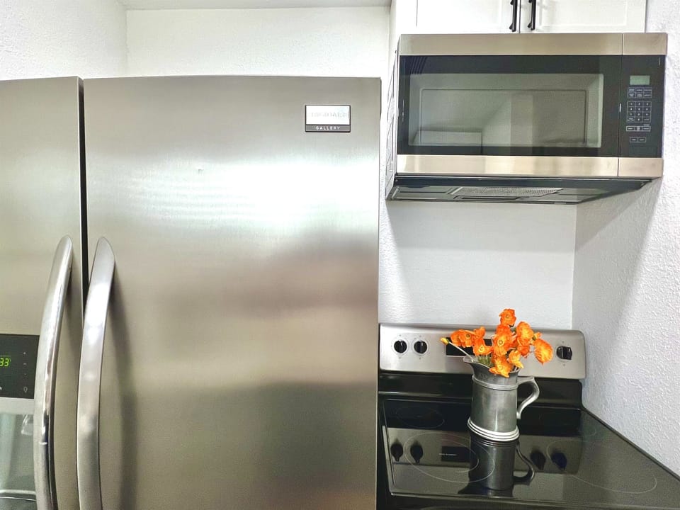 The kitchen features full size refrigerator, and an electric stove and oven, with an overhead microwave.