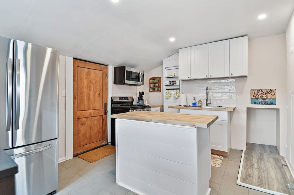 A newly remodeled and nice sized kitchen with butcher block countertops and center island