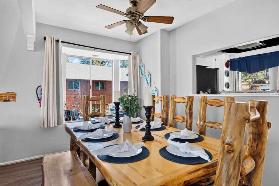 Rustic dining area with log-style seating, mountain-inspired decor, and easy flow into the living room.