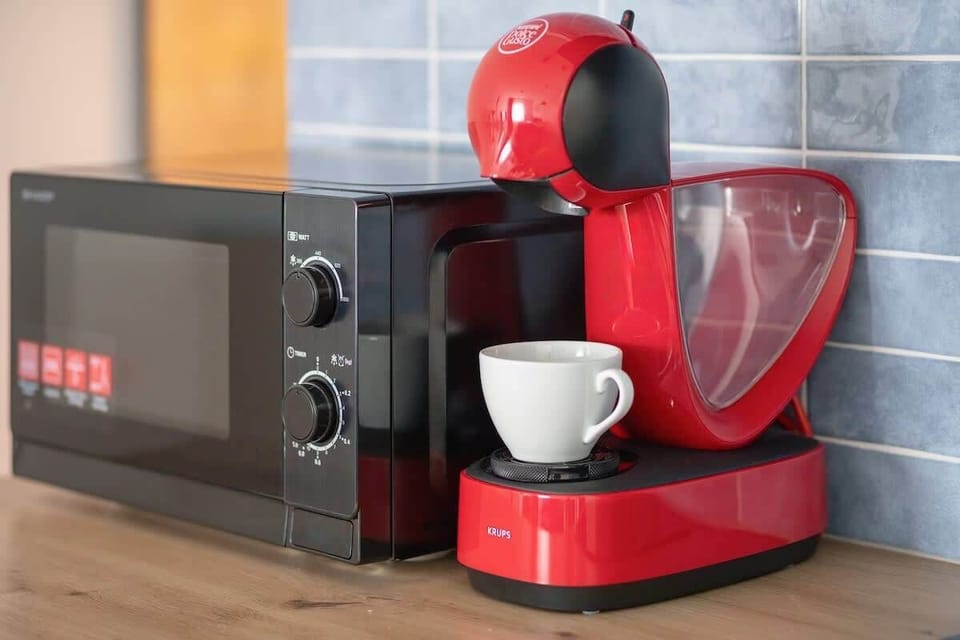 Microwave and a close-up of a coffee machine on the kitchenette counter — perfect for coffee lovers.
