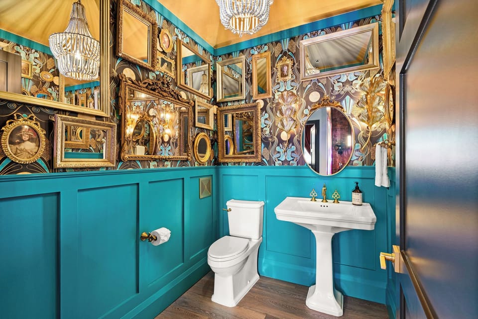 - Bold teal bathroom with gold frames and vintage mirrors   - Chic lighting and patterned walls create a dramatic look   - Unique design offering style, color and picture-ready flair