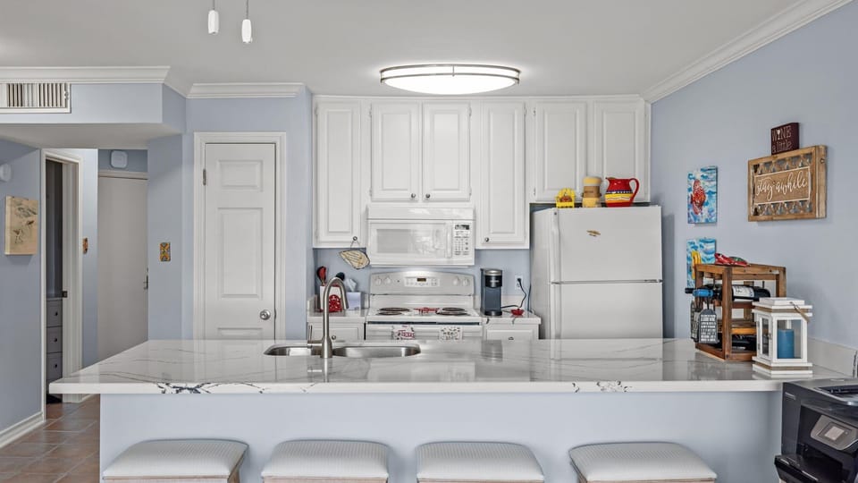 Beautiful white kitchen with quartz counters.