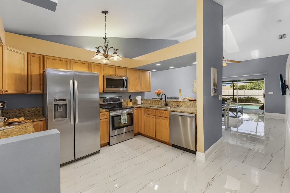 The entry way leads to the kitchen through the living room to the pool