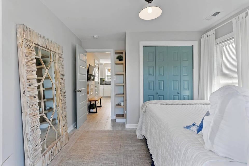 This cheerful bedroom boasts ample natural light from a nice window, creating a bright and inviting atmosphere.  The convenient drawer closet provides ample storage for all your belongings, keeping your space organized and clutter-free.  This well-lit and functional room is perfect for relaxation and productivity.
