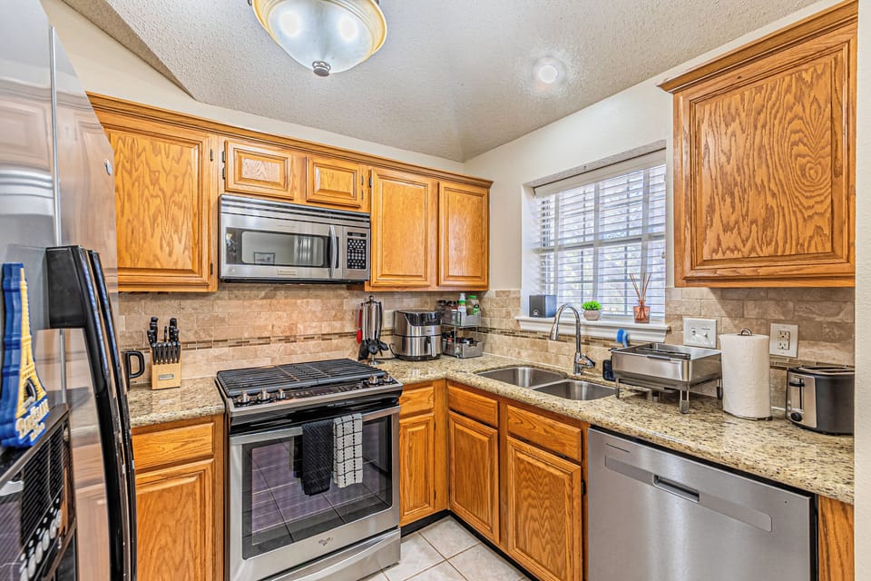 Second view of kitchen showing stainless appliances and prep space