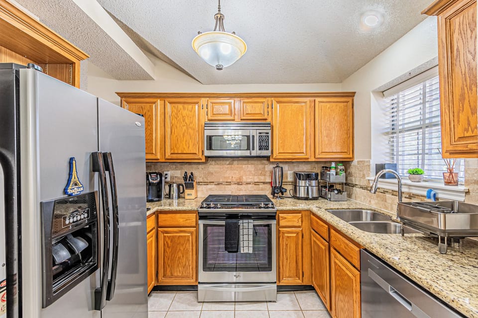 Fully stocked kitchen with cookware, utensils, and coffee bar.