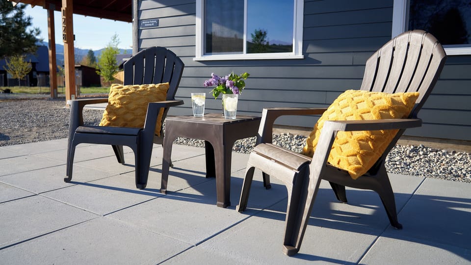 Private patio with adirondack chairs and table.