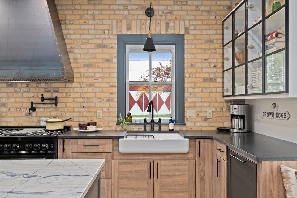 Farmhouse sink perfectly positioned beneath a sunny window view.