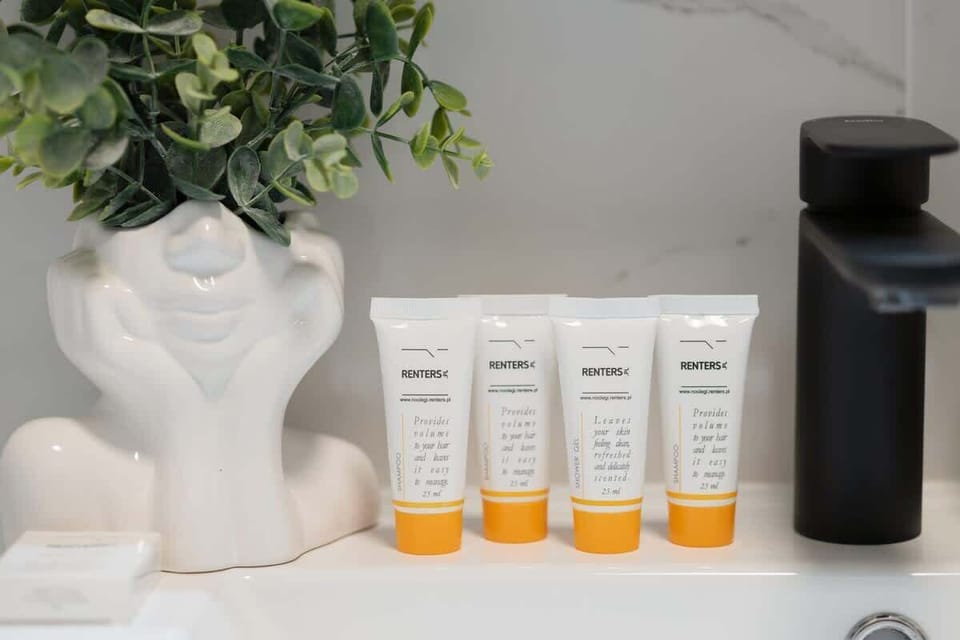 A close-up of a bathroom shelf with products, neatly arranged next to a stylish decorative vase, showcasing the studio’s modern, polished bathroom setup.