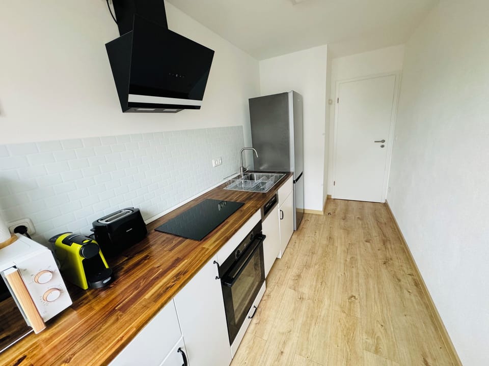 Fully equipped kitchen with modern appliances, includes a fridge with freezer