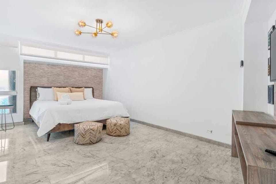 The first bedroom of the accommodation boasts a generously sized king bed, which provides ample space for a restful night's sleep.