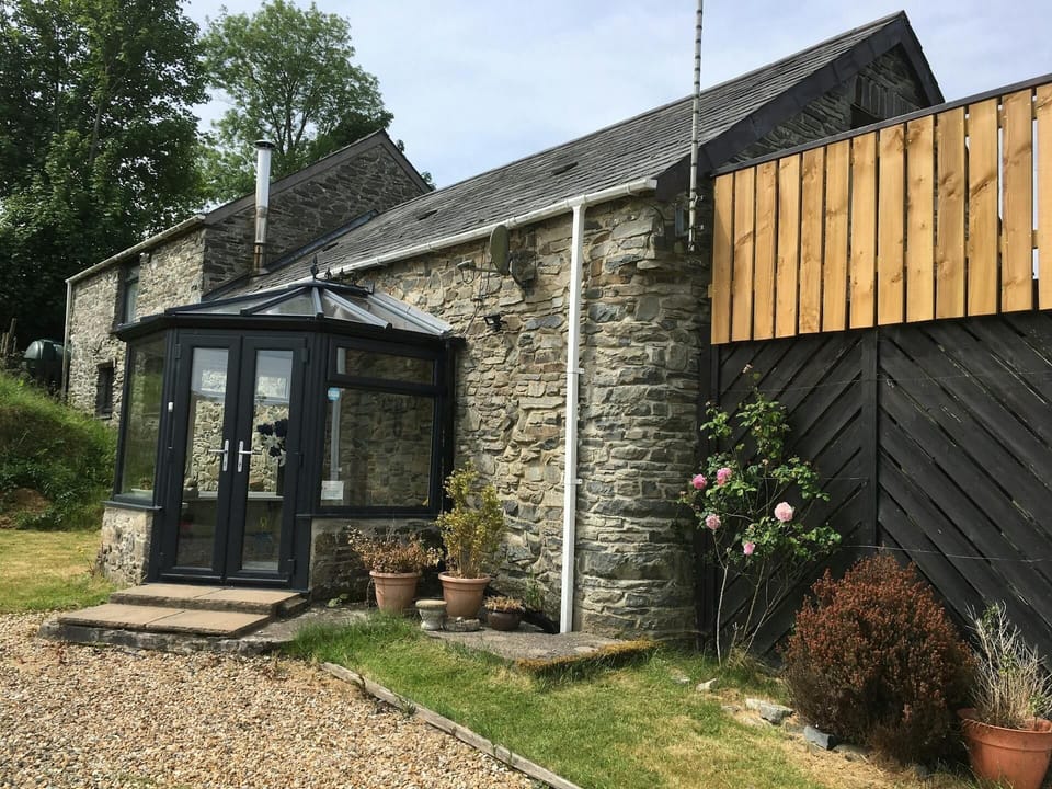 The front of the property with porch and shrubs and grass