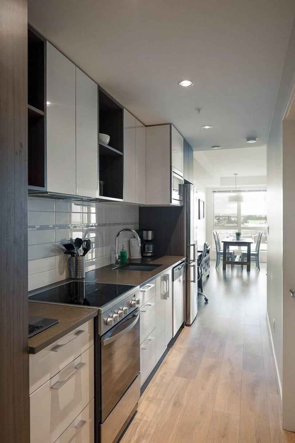 Another clean look down the functional galley-style kitchen corridor, showcasing plenty of meal prep space.