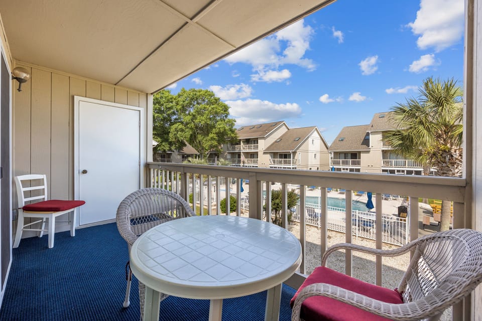 Relax on the carpeted patio featuring cozy seating and enjoy stunning pool views—perfect for unwinding with your morning coffee or evening drink.