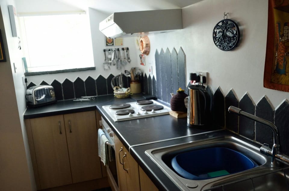 Kitchen with sink, built-in oven and hob, toaster, kettle and window