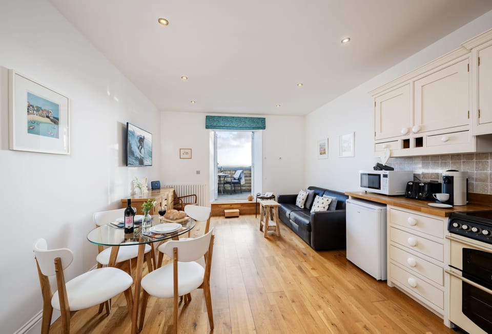 4 Fernhill, Carbis Bay: The bright open-plan living area is a delight, with a comfortable leather sofa, armchair and doors leading to your balcony with sea views