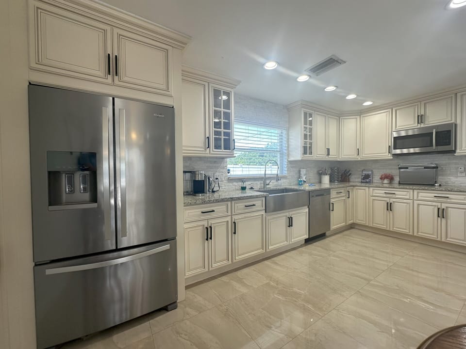 Fully equipped kitchen with refrigerator, stove, microwave, air fryer and more.