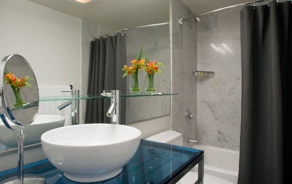 Elegant bathroom equipped with sleek fixtures and fresh floral accents, offering a spa-like experience right in your room.