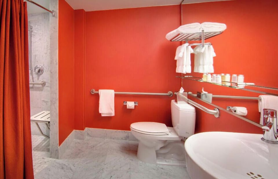 Refresh in style in this strikingly modern bathroom, boasting bold red decor and top-tier amenities for a luxurious and invigorating morning routine.