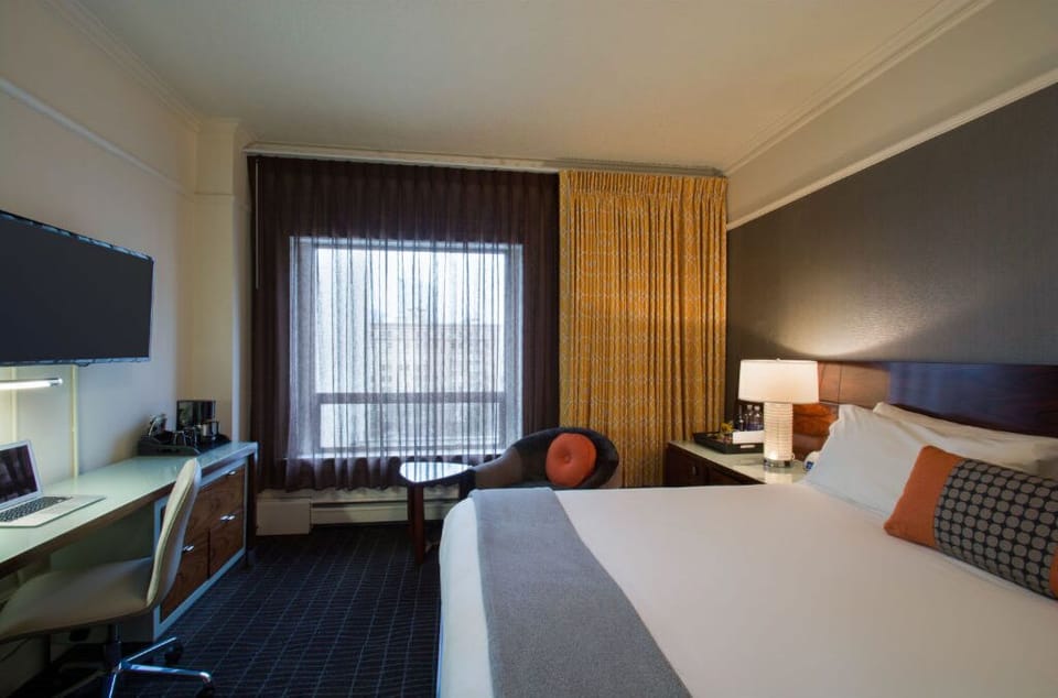 Generously sized King room with modern amenities, featuring a dedicated workspace and expansive city views.
