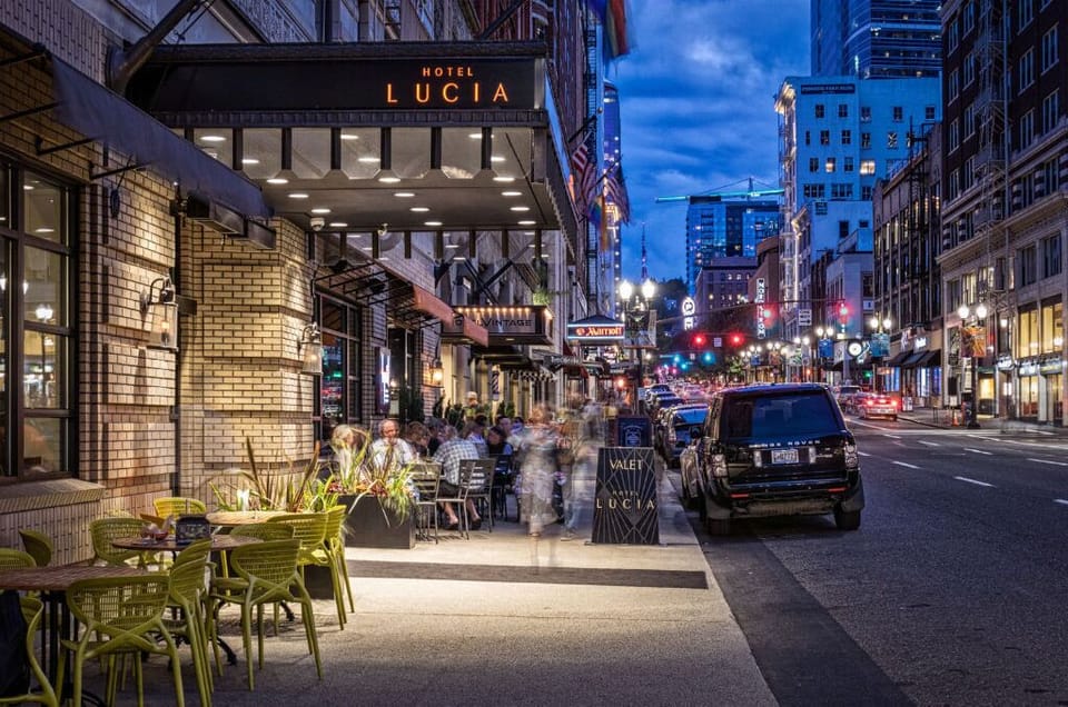Evening view of the bustling streets outside Hotel Lucia, featuring the glowing hotel marquee.