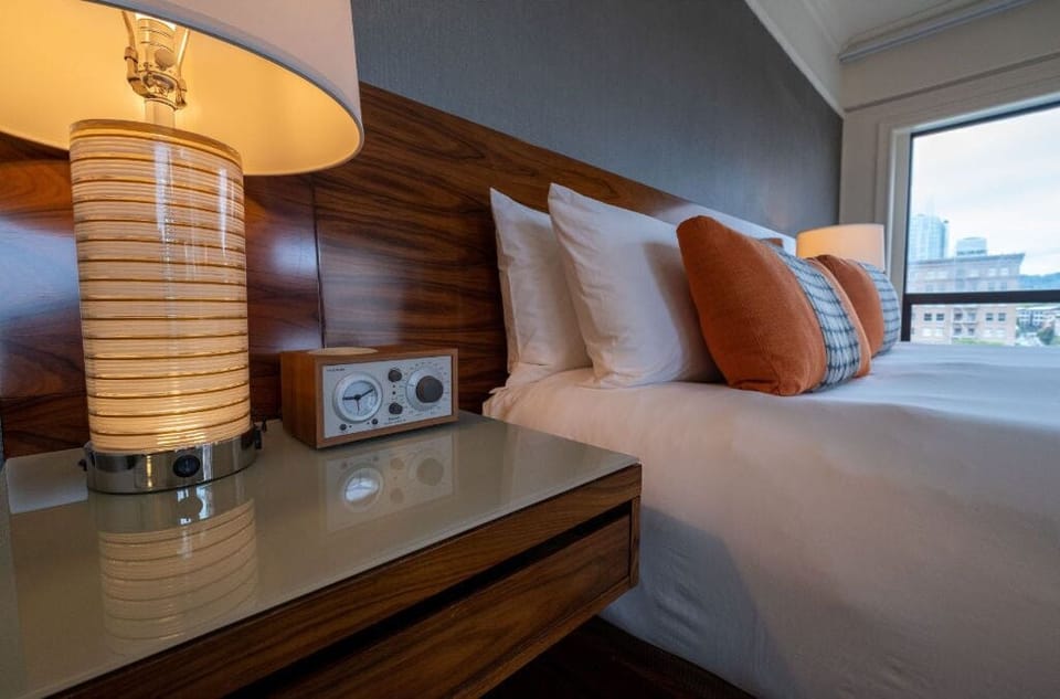 Queen room detail highlighting the chic bedside setting with stylish decor and natural light.