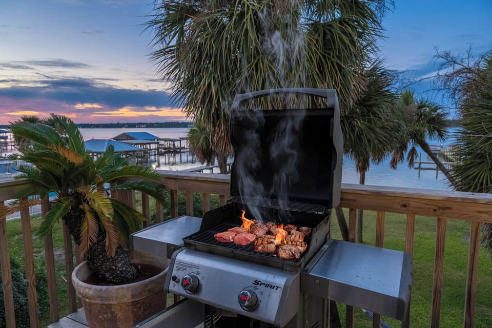 Sunset grilling with palm trees and waterfront views — pure serenity!