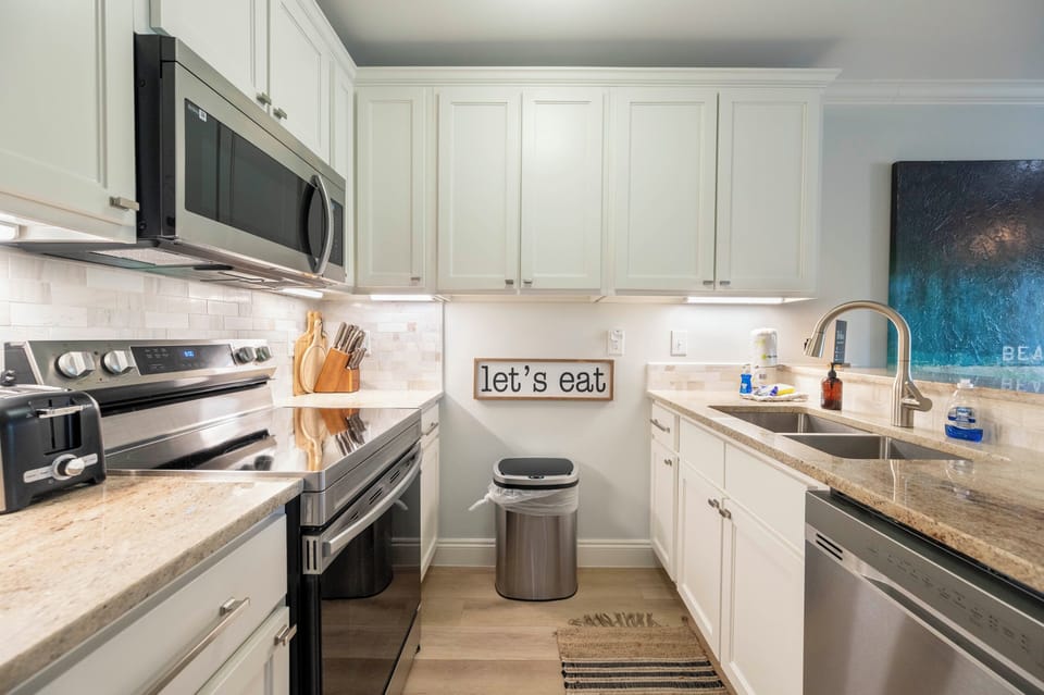 Modern kitchen elegance: Stainless steel appliances and cozy decor charm.