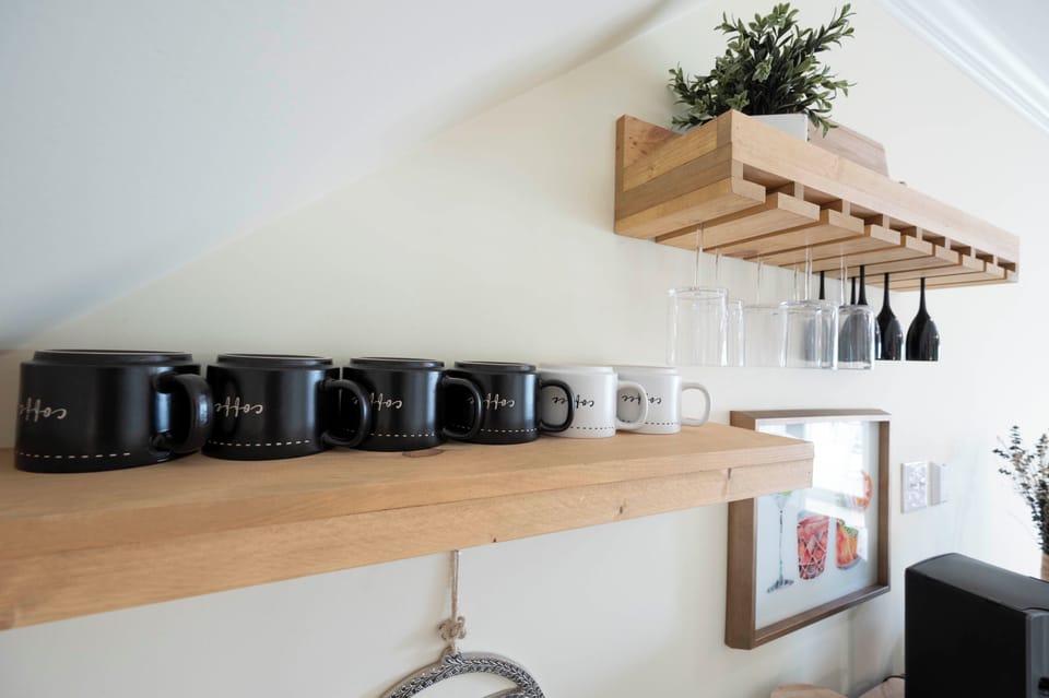 Stylish kitchen shelves with cozy coffee mugs and elegant glassware display.